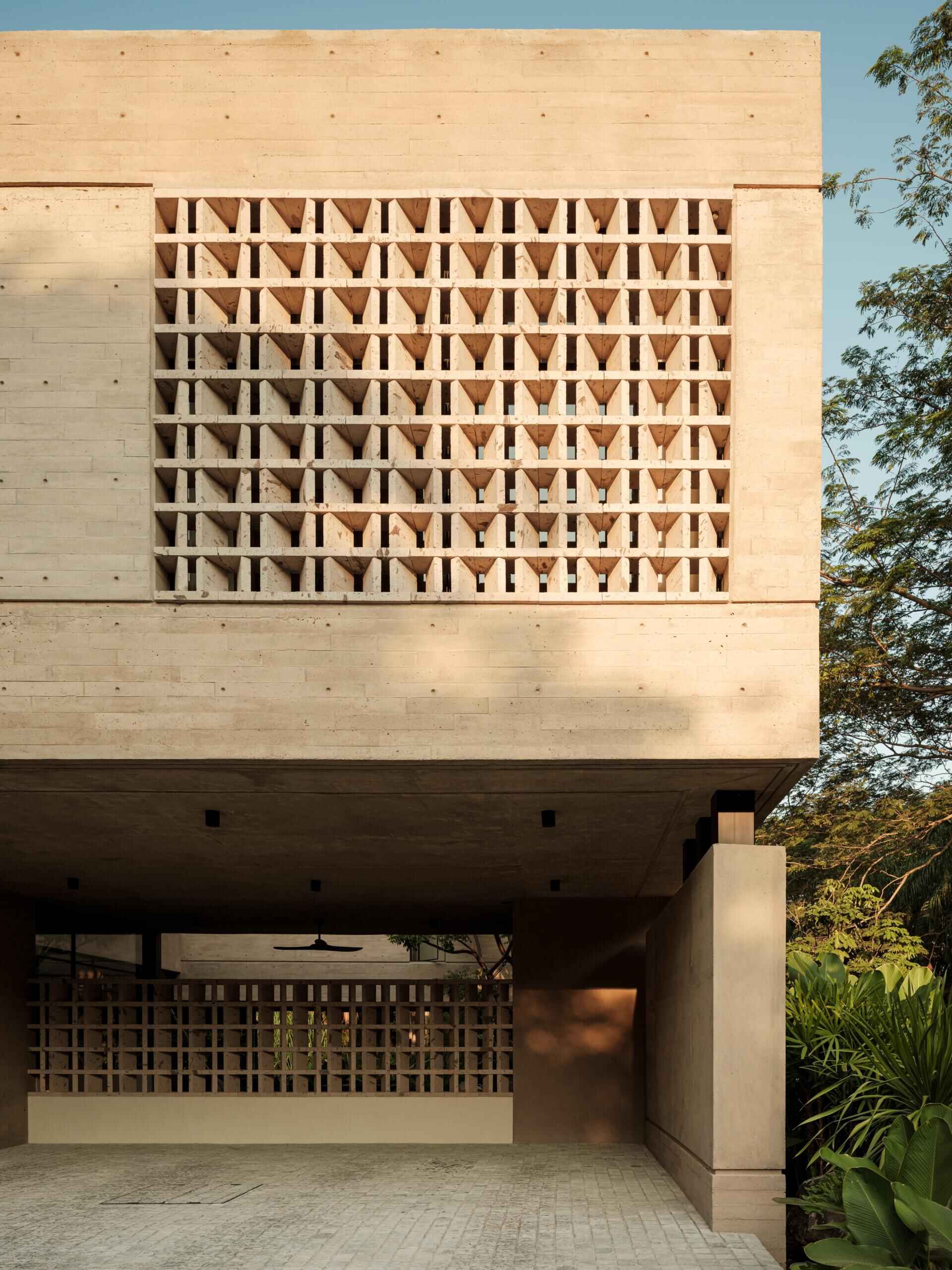 Explore the architecture of Casa Akina in Mexico by Di Frenna arquitectos, featuring board-formed concrete, geometric breeze-block facades, cantilevered volumes, natural stone, and tropical landscaping.
