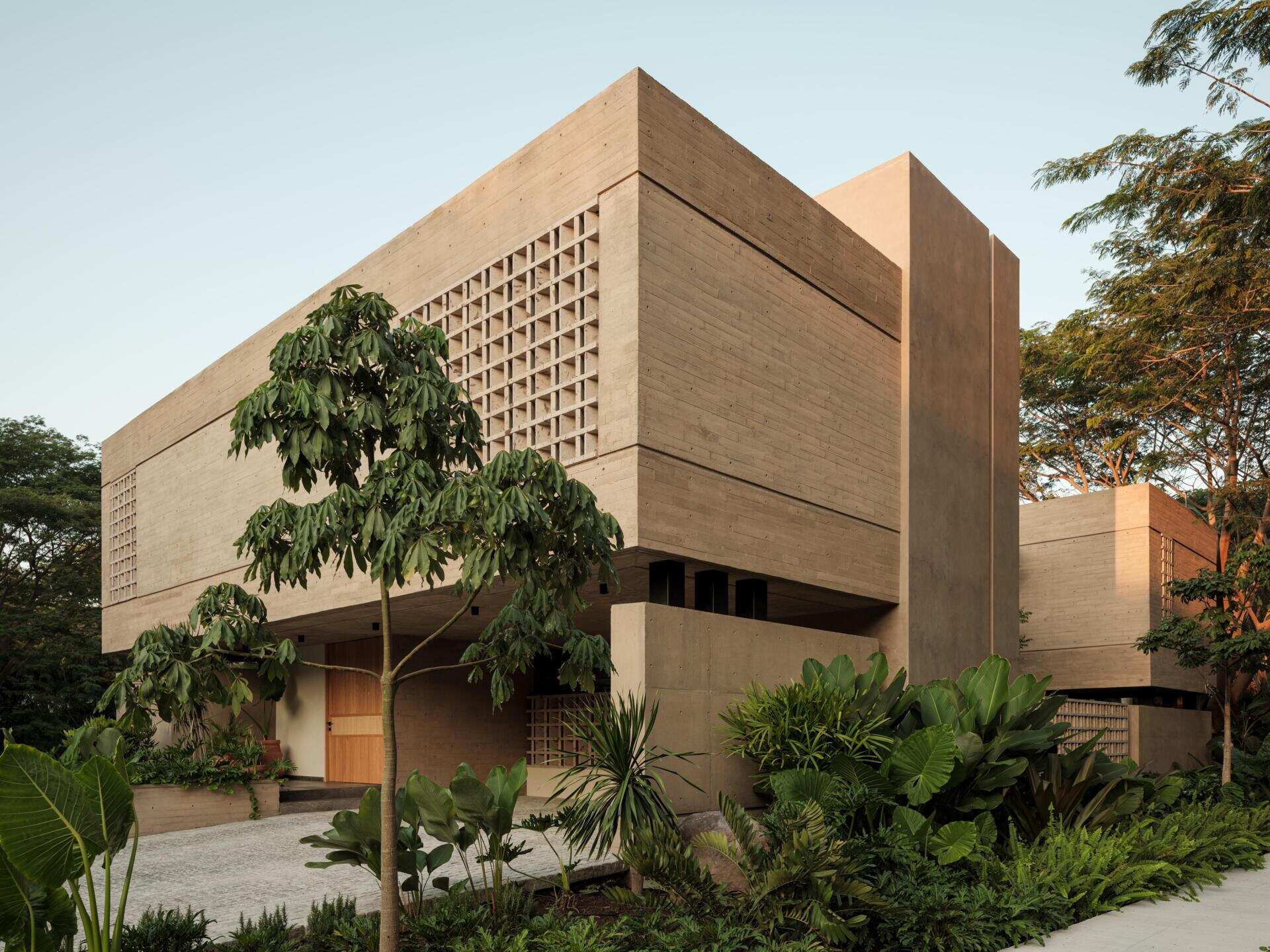 Explore the architecture of Casa Akina in Mexico by Di Frenna arquitectos, featuring board-formed concrete, geometric breeze-block facades, cantilevered volumes, natural stone, and tropical landscaping.
