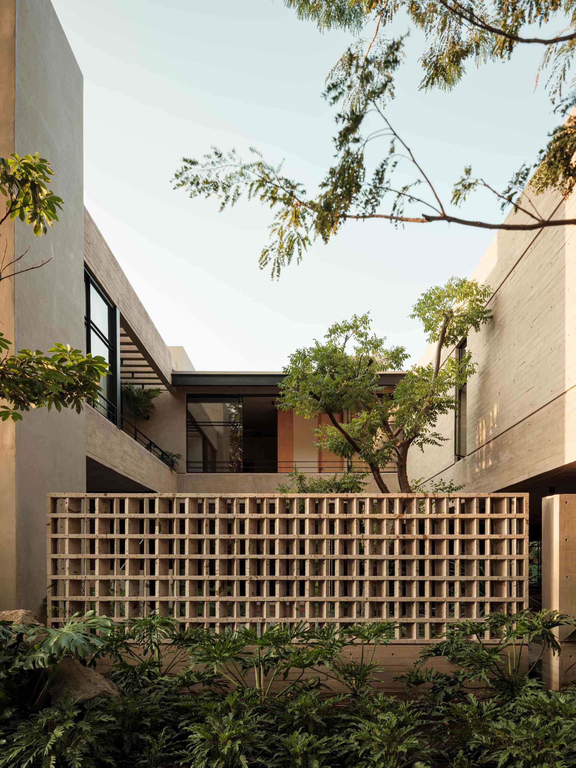 Explore the architecture of Casa Akina in Mexico by Di Frenna arquitectos, featuring board-formed concrete, geometric breeze-block facades, cantilevered volumes, natural stone, and tropical landscaping.