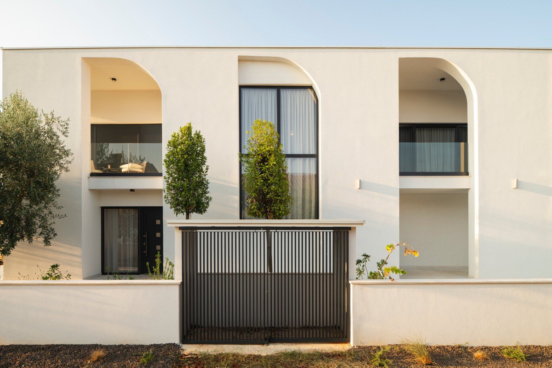 Discover the architecture of Arc House in Istria, Croatia, by Ivan Gavran Vlahovic. This contemporary white villa features geometric half-arches, symmetrical façades, recessed balconies and minimalist Mediterranean architecture inspired by classical country houses.