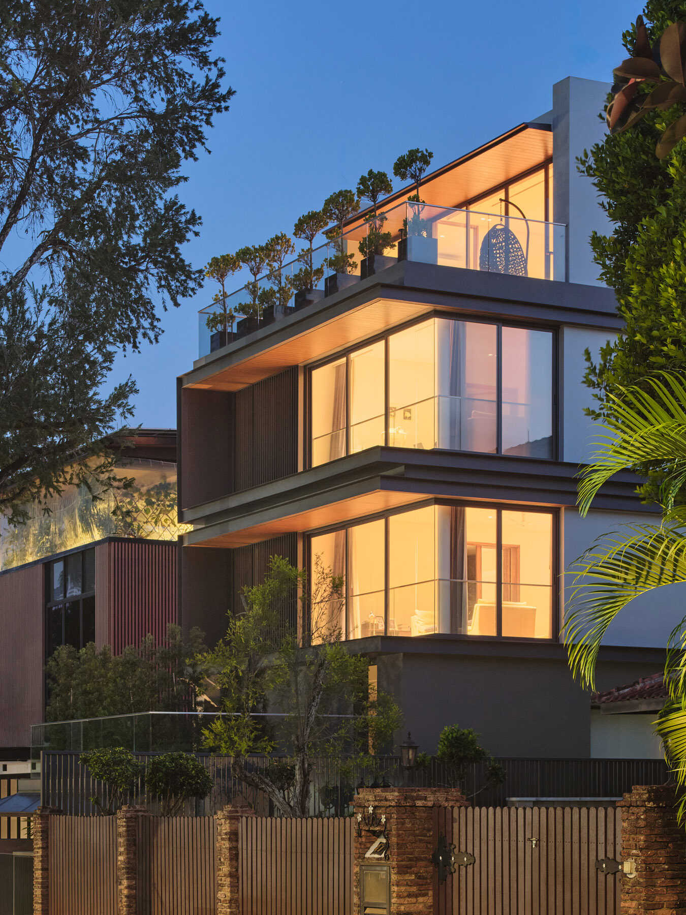 Discover the contemporary architecture of JS-House in Singapore, featuring layered horizontal forms, floor-to-ceiling corner windows, planted terraces, and rooftop greenery.