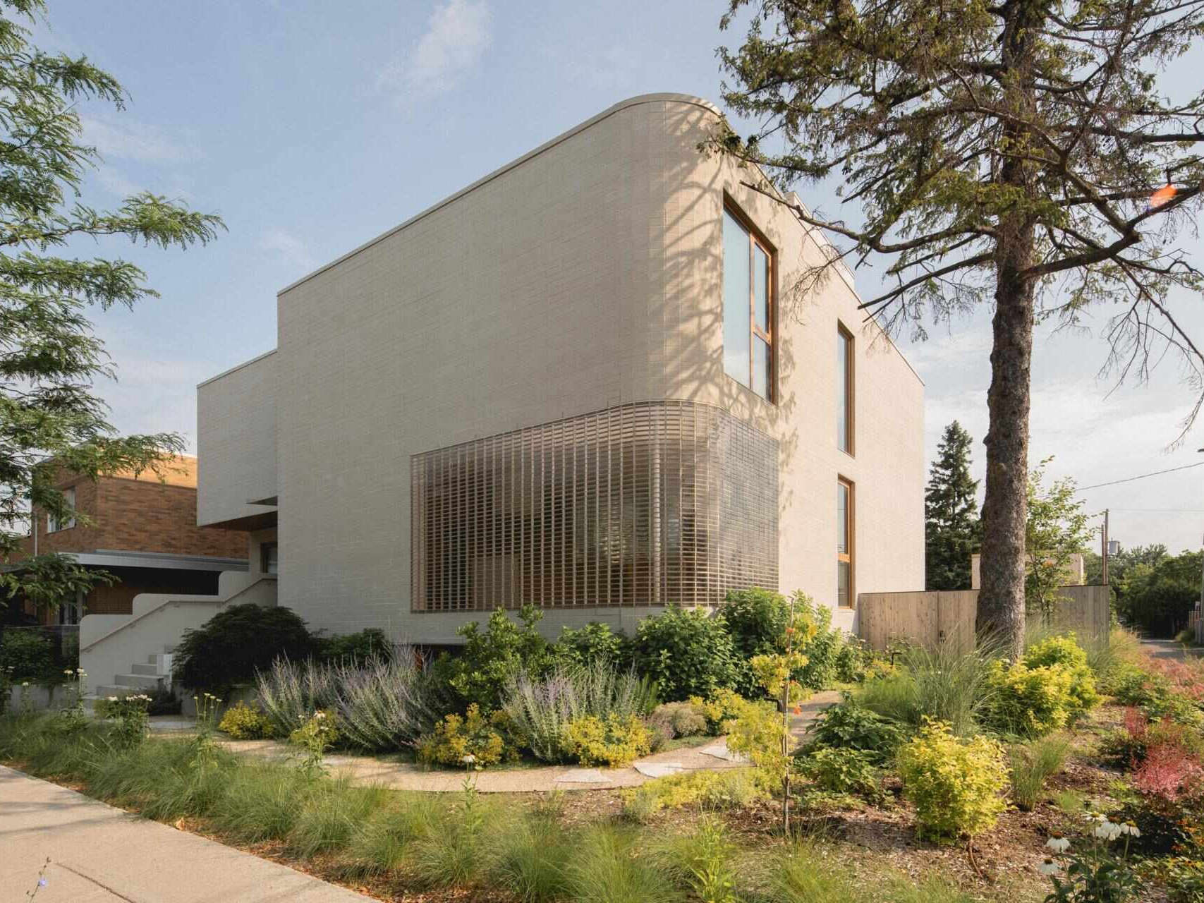 Discover The Lens by MU Architecture, a modern family home in Montreal, Canada, featuring Japanese-inspired minimalism, curved glass brick walls, warm wood interiors, and contemporary architecture.