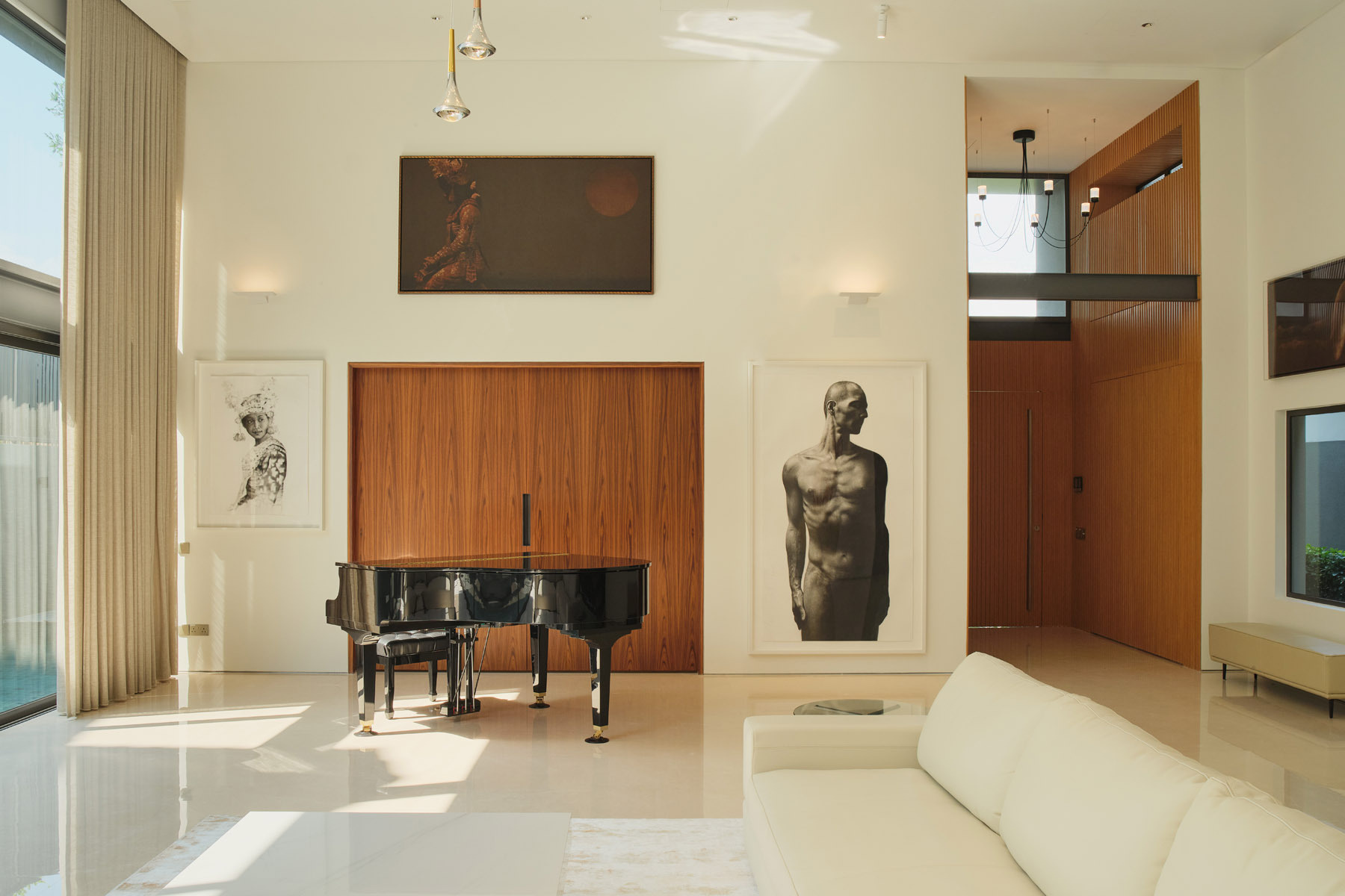 Take a look inside this Singapore home featuring a grand piano, an impressive art collection, and a bar concealed behind timber doors, complete with stone countertops and display shelving.
