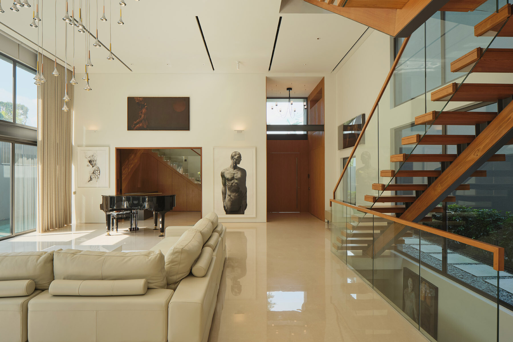 Take a look inside this Singapore home featuring a grand piano, an impressive art collection, and a bar concealed behind timber doors, complete with stone countertops and display shelving.