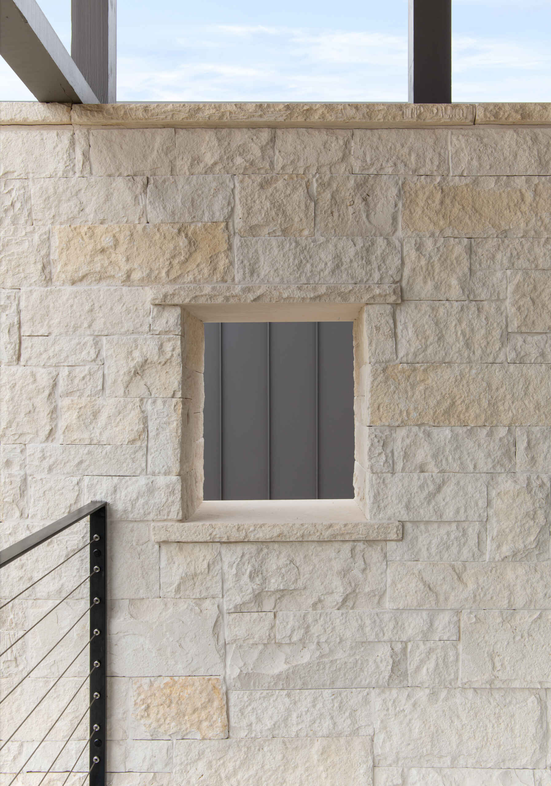 Two modern Texas homes by Jeff Garnett Architect combine native limestone walls, dark metal cladding, and contrasting rooflines.