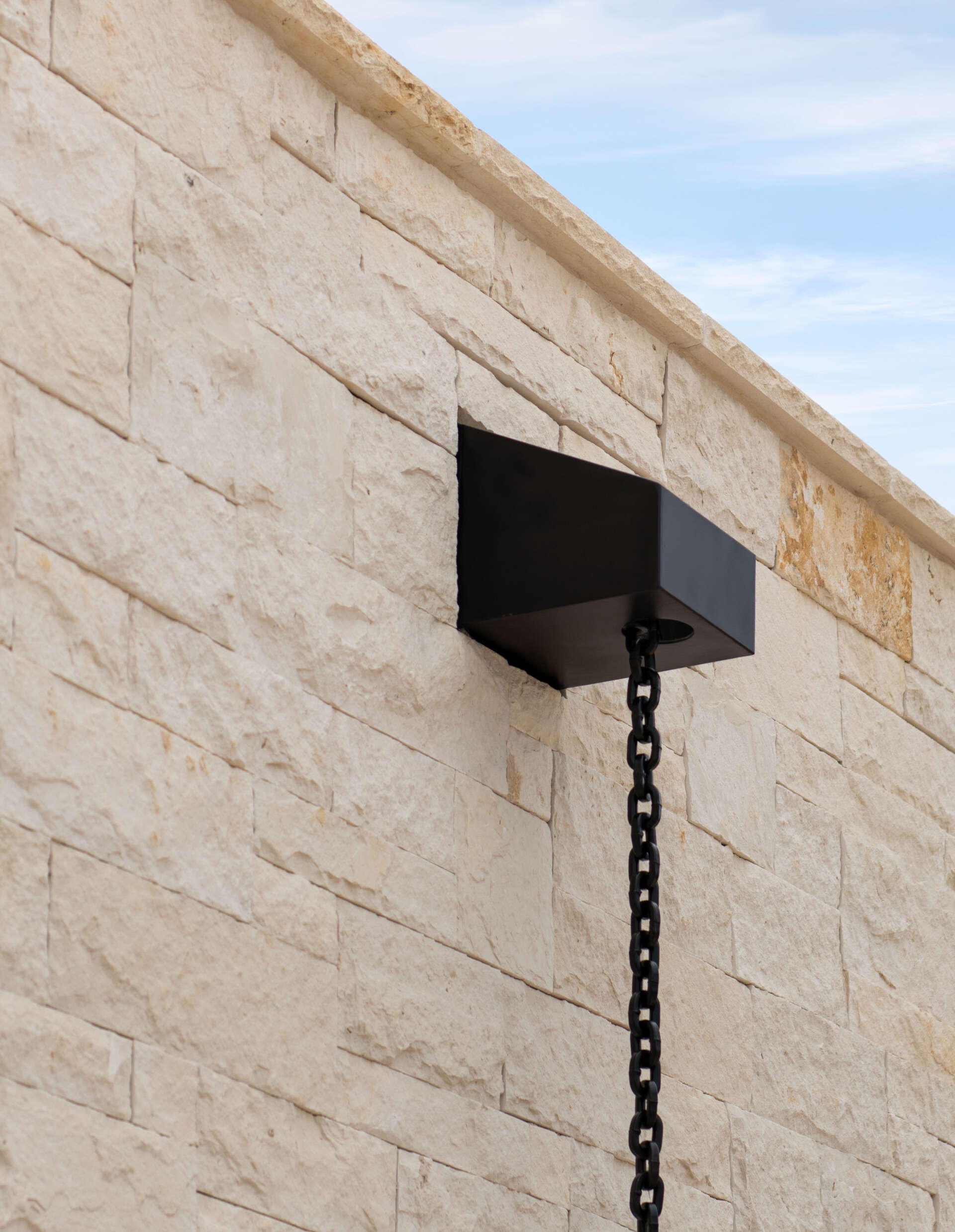 Two modern Texas homes by Jeff Garnett Architect combine native limestone walls, dark metal cladding, and contrasting rooflines.