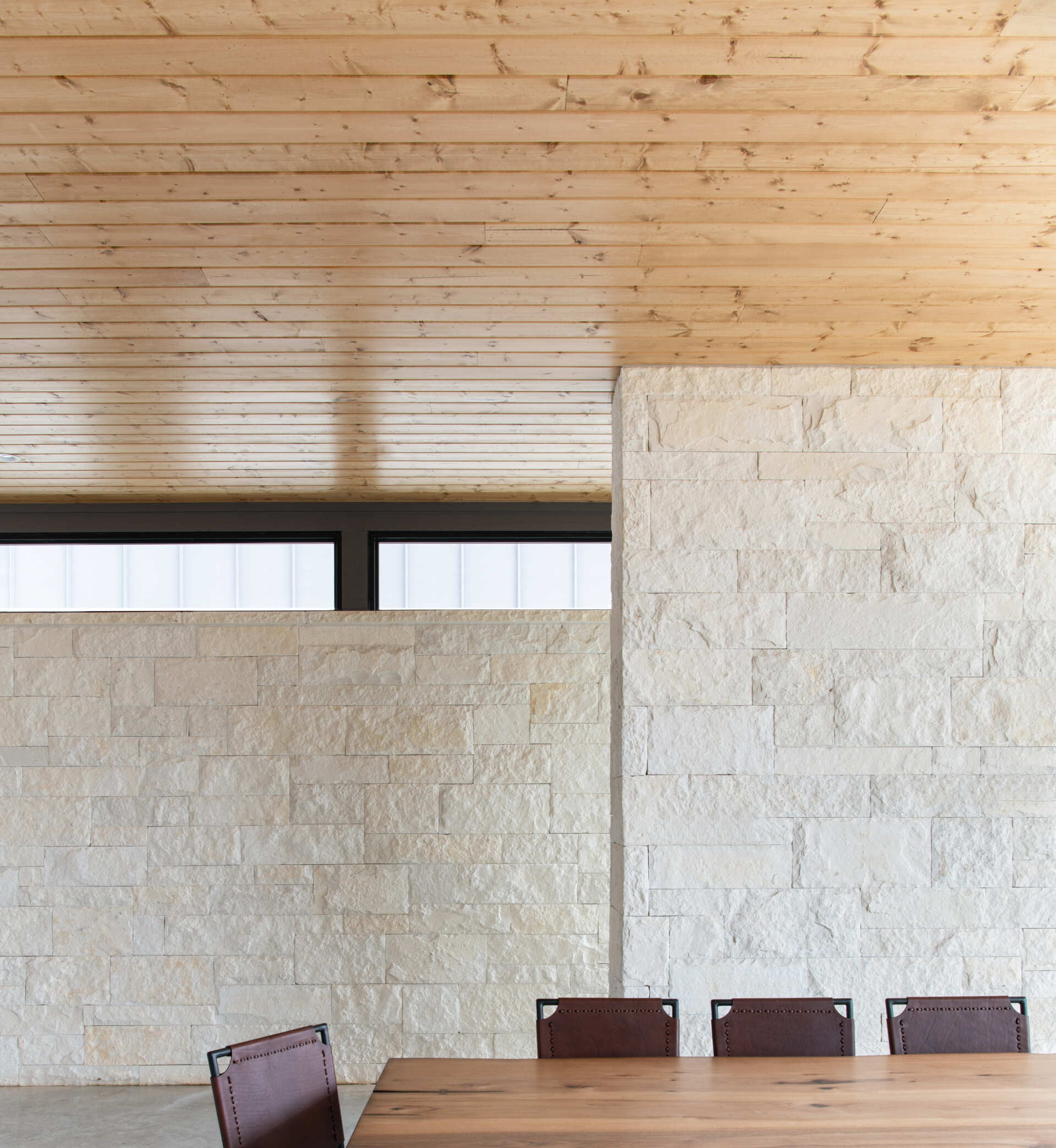 Small windows framed by limestone create unexpected architectural details, including a view into a miniature cactus garden.