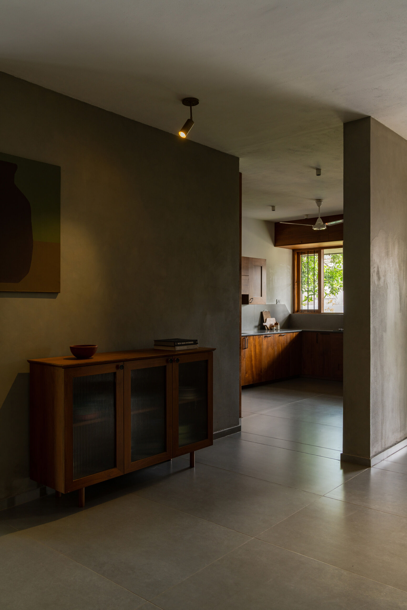This contemporary U-shaped kitchen combines wood cabinets, quartz countertops, black range hoods, and a large garden-facing window that welcomes morning sunlight.
