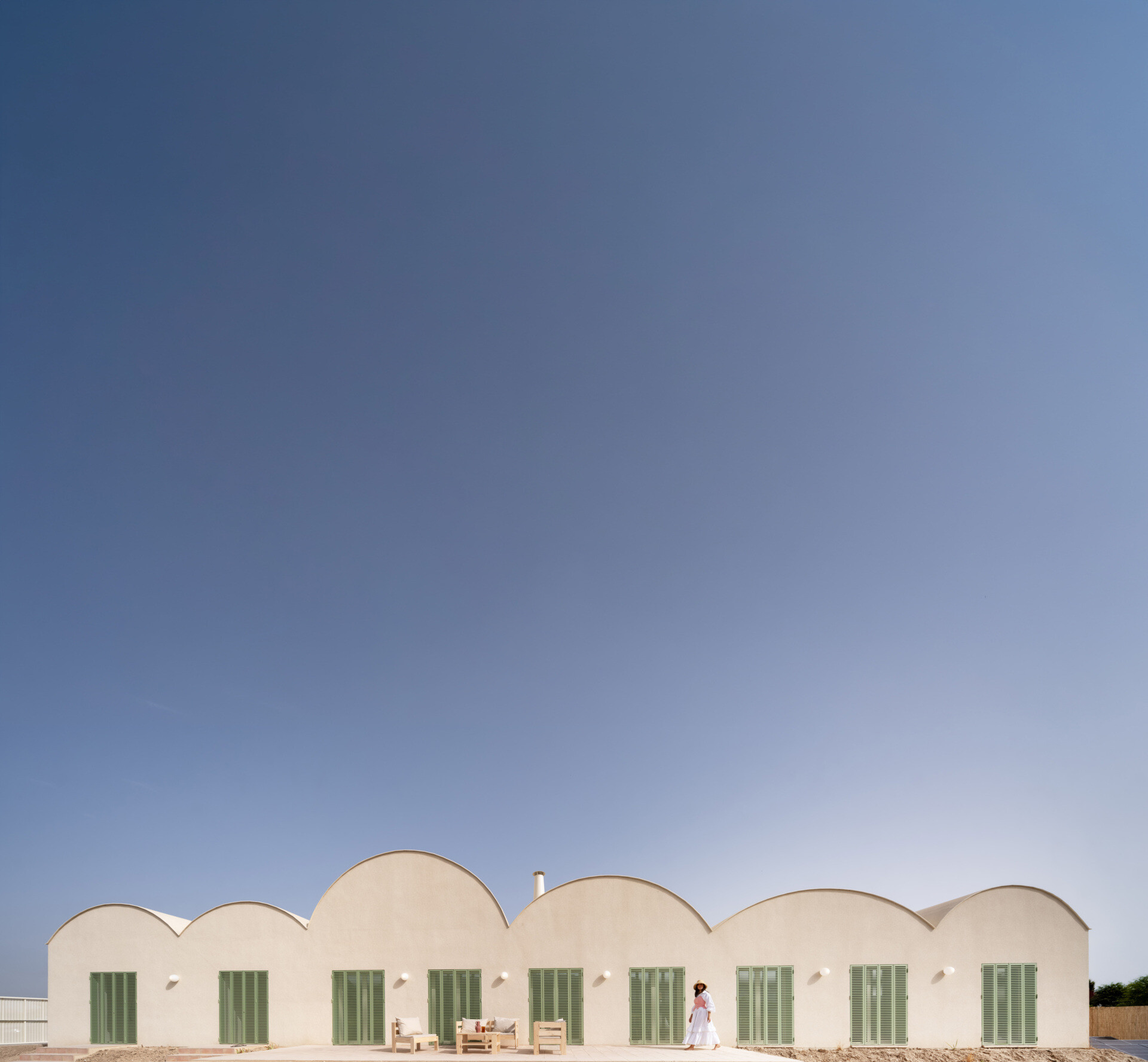 Curved Catalan vaulted roofs, a pale cork exterior, and green Mediterranean shutters give this contemporary home its unique character.