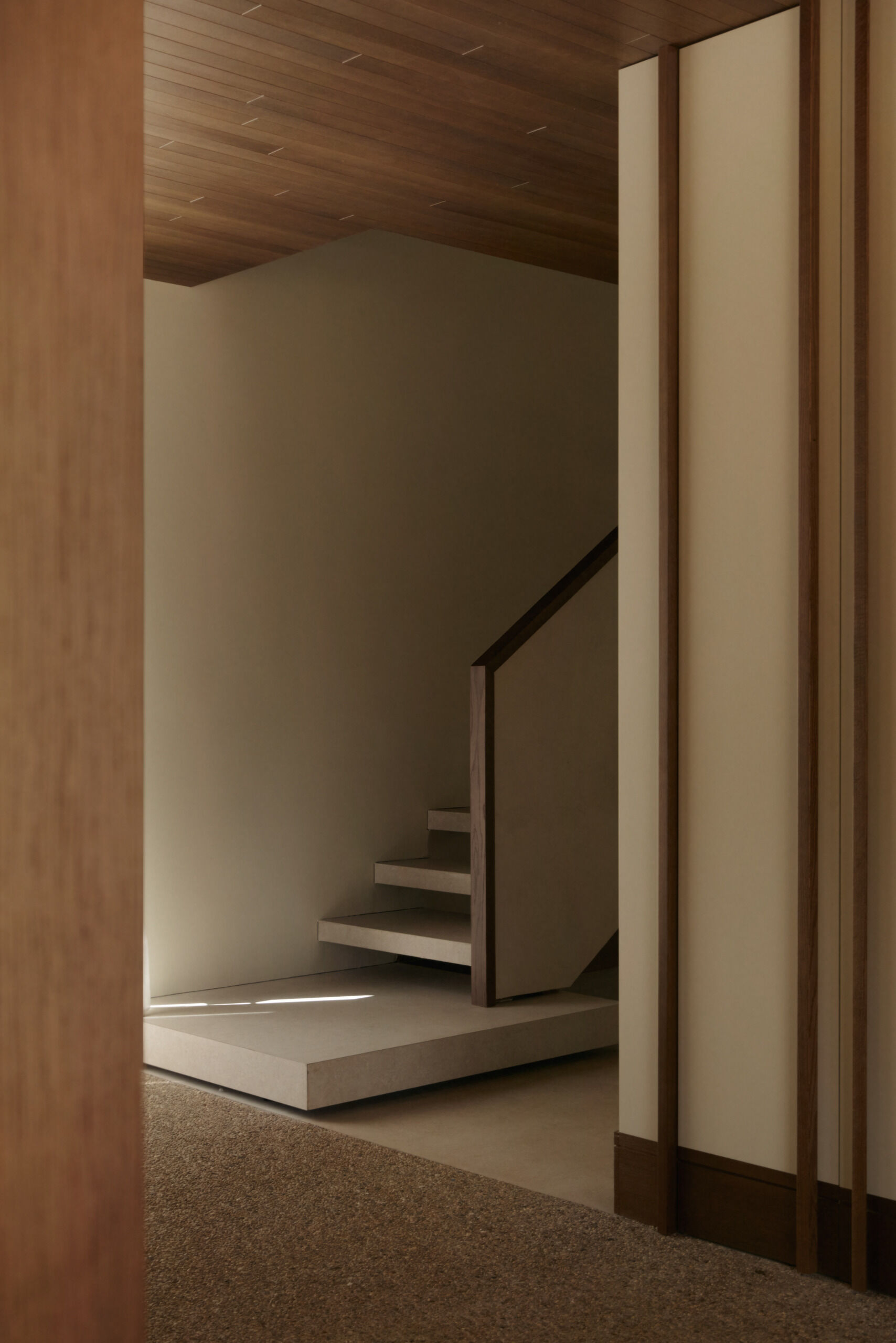 Explore a modern floating-style staircase with cantilevered concrete steps, open risers, minimalist detailing, and an oversized platform step in a contemporary Spanish home.