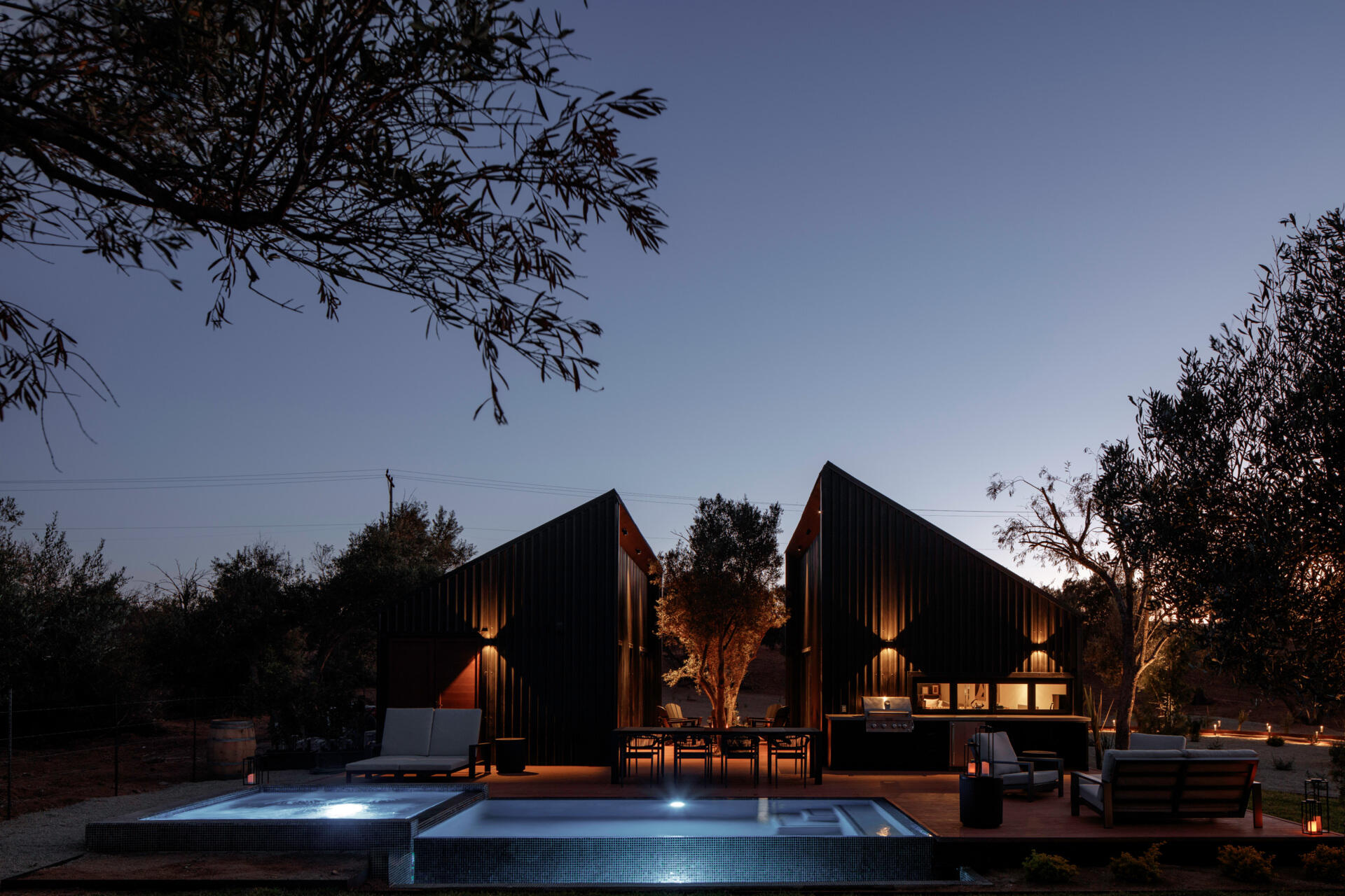 Discover the modern swimming pool at Serentha Cabin by ORTO STUDIO in Baja California, Mexico. A rectangular pool with blue mosaic tiles, a smaller raised pool, timber decking, and scenic olive grove views creates an inviting outdoor space.