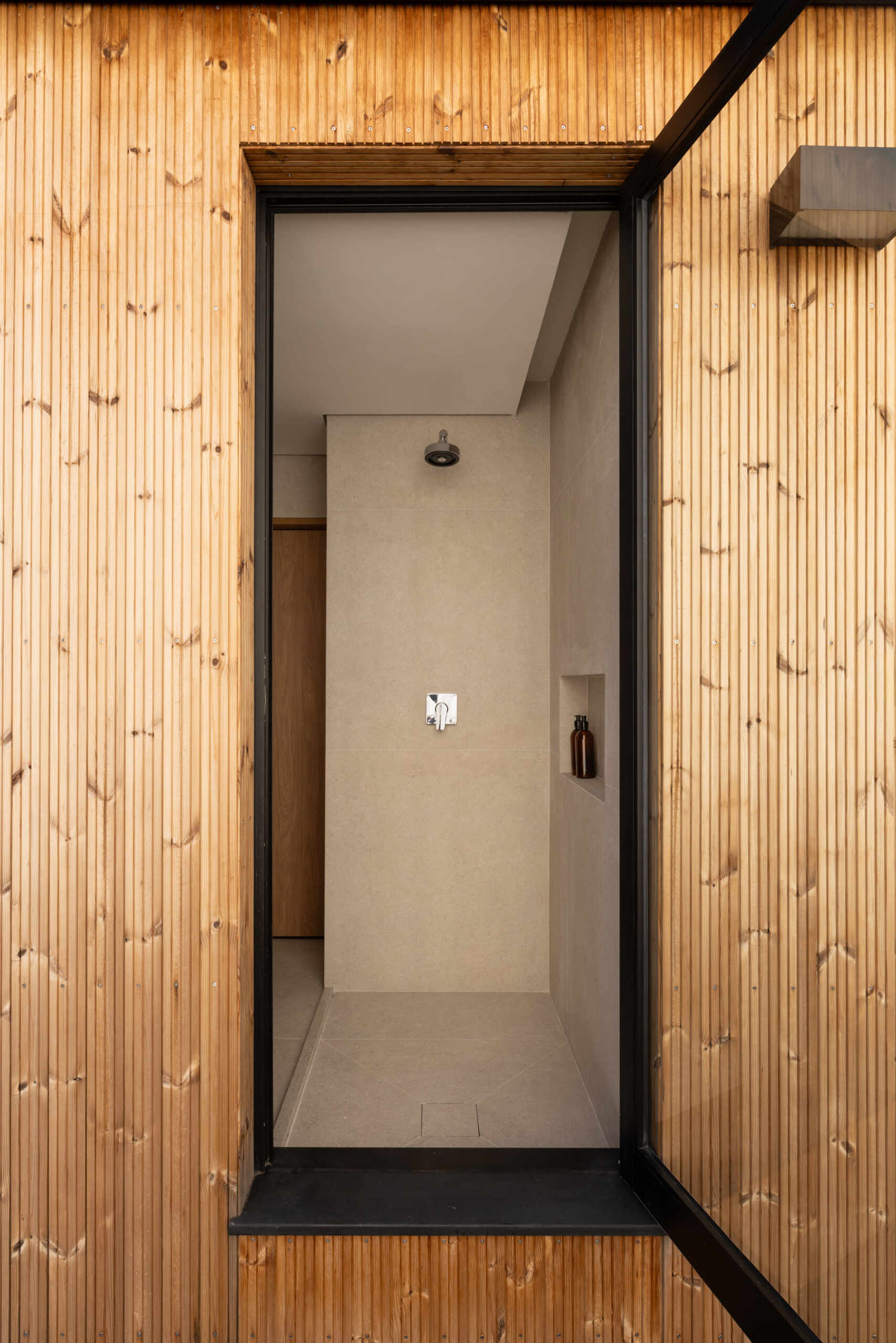 Explore the space-saving layout of Casa M38, a small prefab home with an open kitchen and living room, an integrated dining table, a private bedroom with a workspace, and a bathroom.
