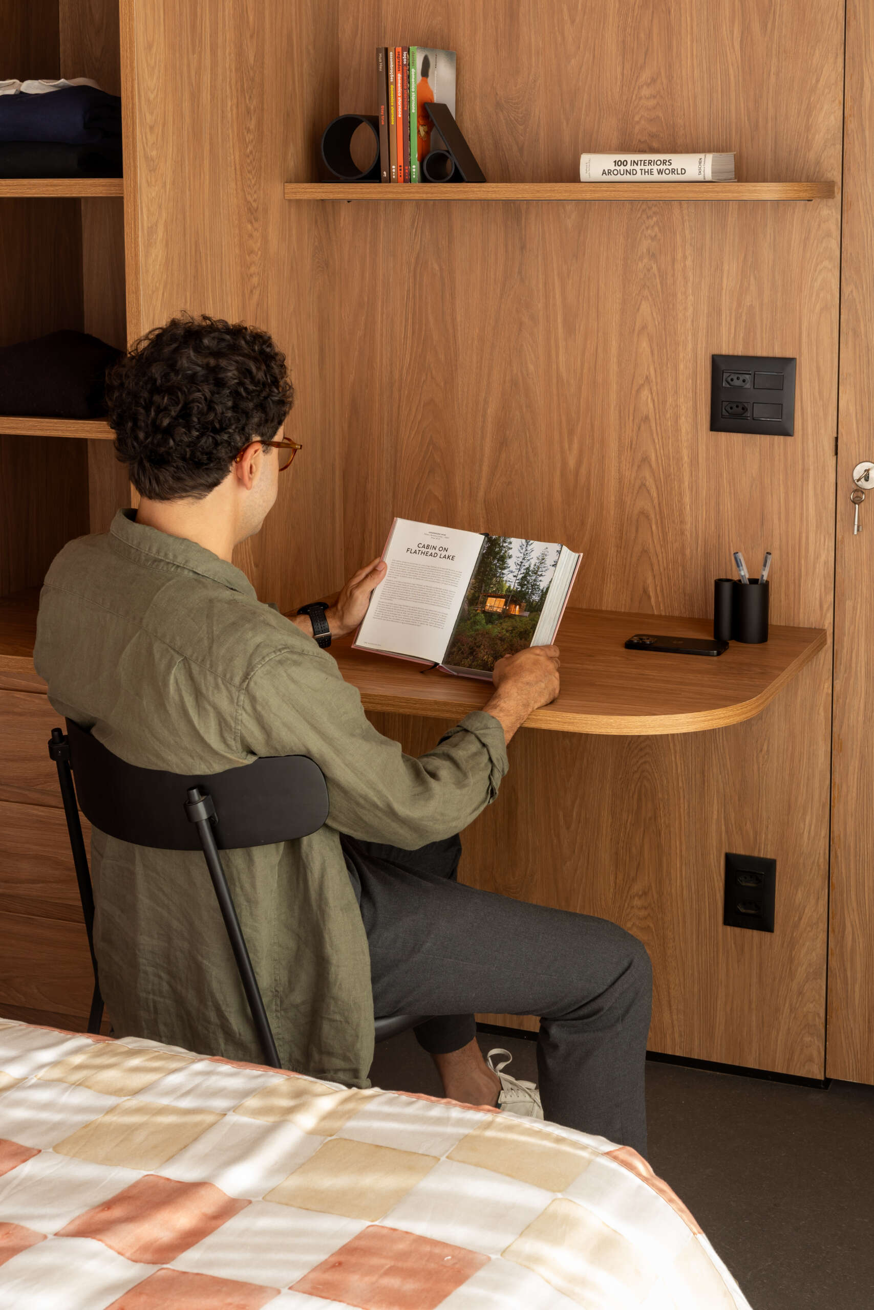 Explore the space-saving layout of Casa M38, a small prefab home with an open kitchen and living room, an integrated dining table, a private bedroom with a workspace, and a bathroom.