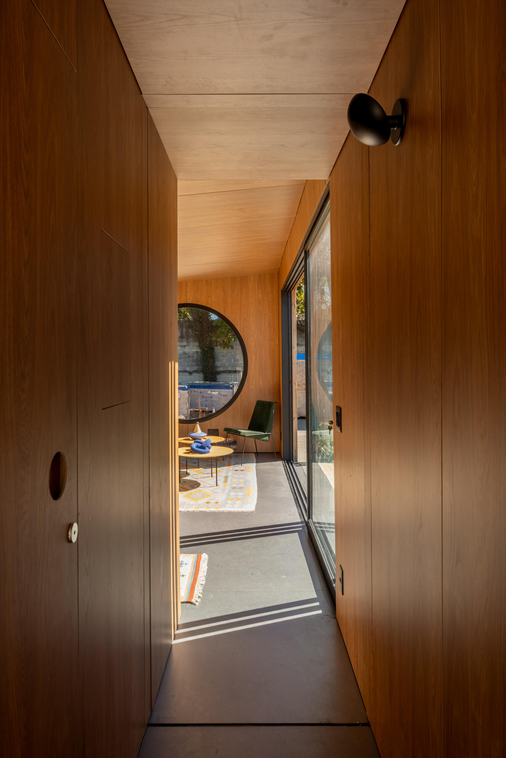 Explore the space-saving layout of Casa M38, a small prefab home with an open kitchen and living room, an integrated dining table, a private bedroom with a workspace, and a bathroom.