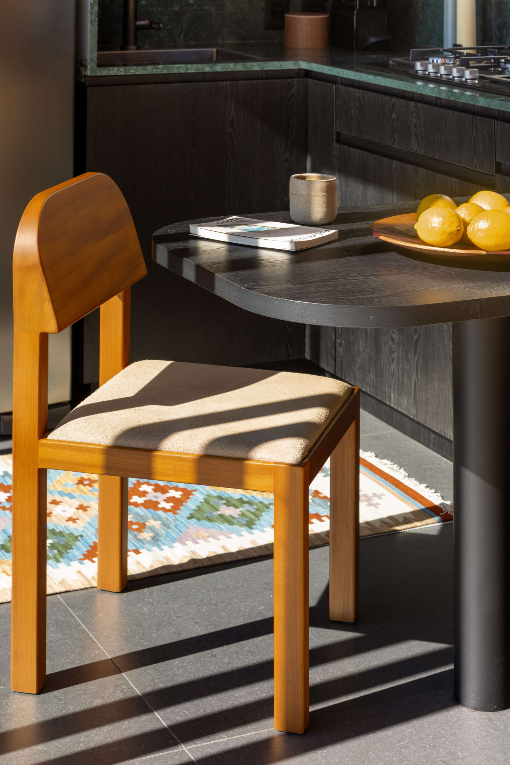 Explore the space-saving layout of Casa M38, a small prefab home with an open kitchen and living room, an integrated dining table, a private bedroom with a workspace, and a bathroom.