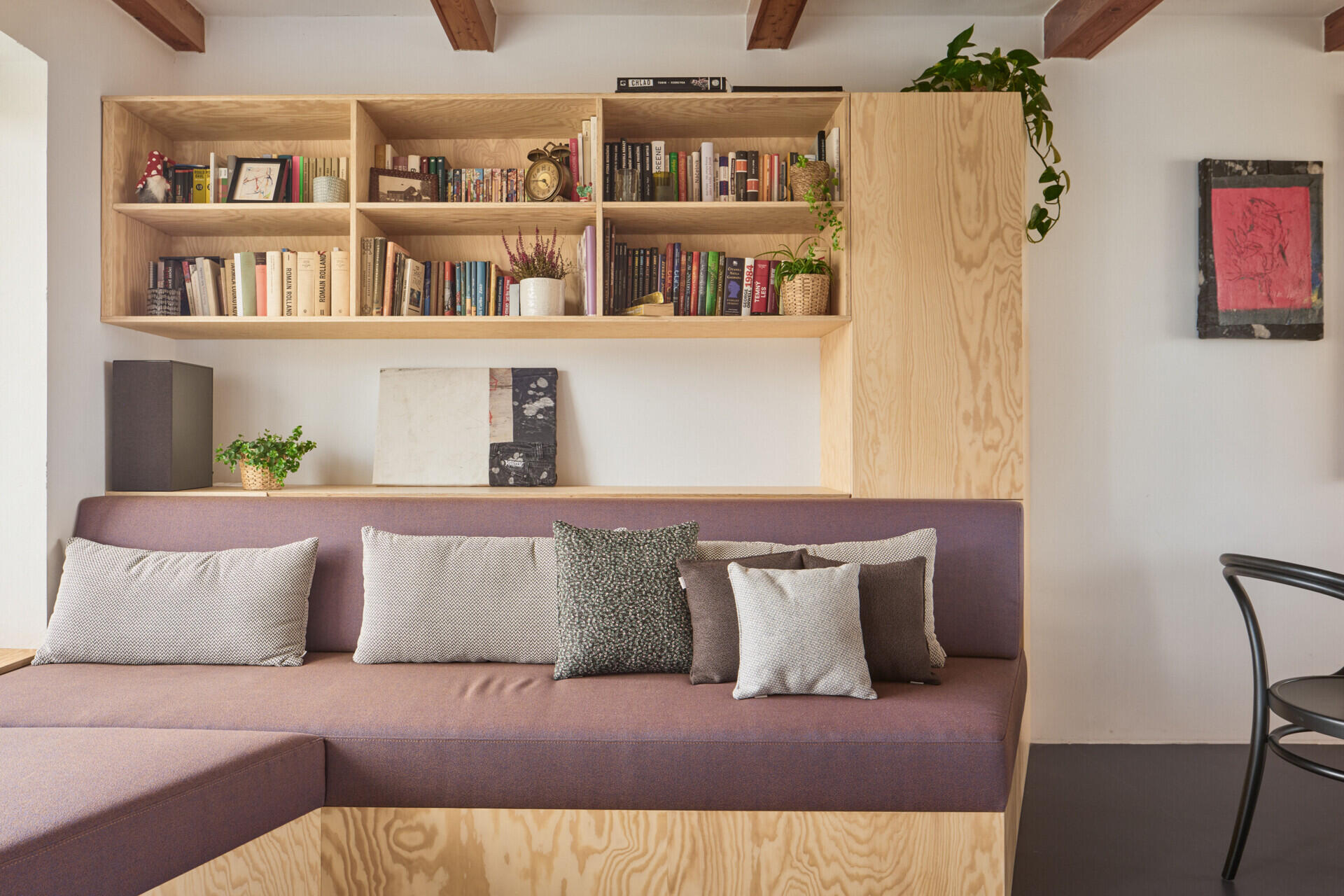 Custom pine plywood furniture transforms part of this renovated Czech home by Facha architekti into a relaxed secondary living space, with built-in seating, bookshelves and storage making efficient use of the compact interior.